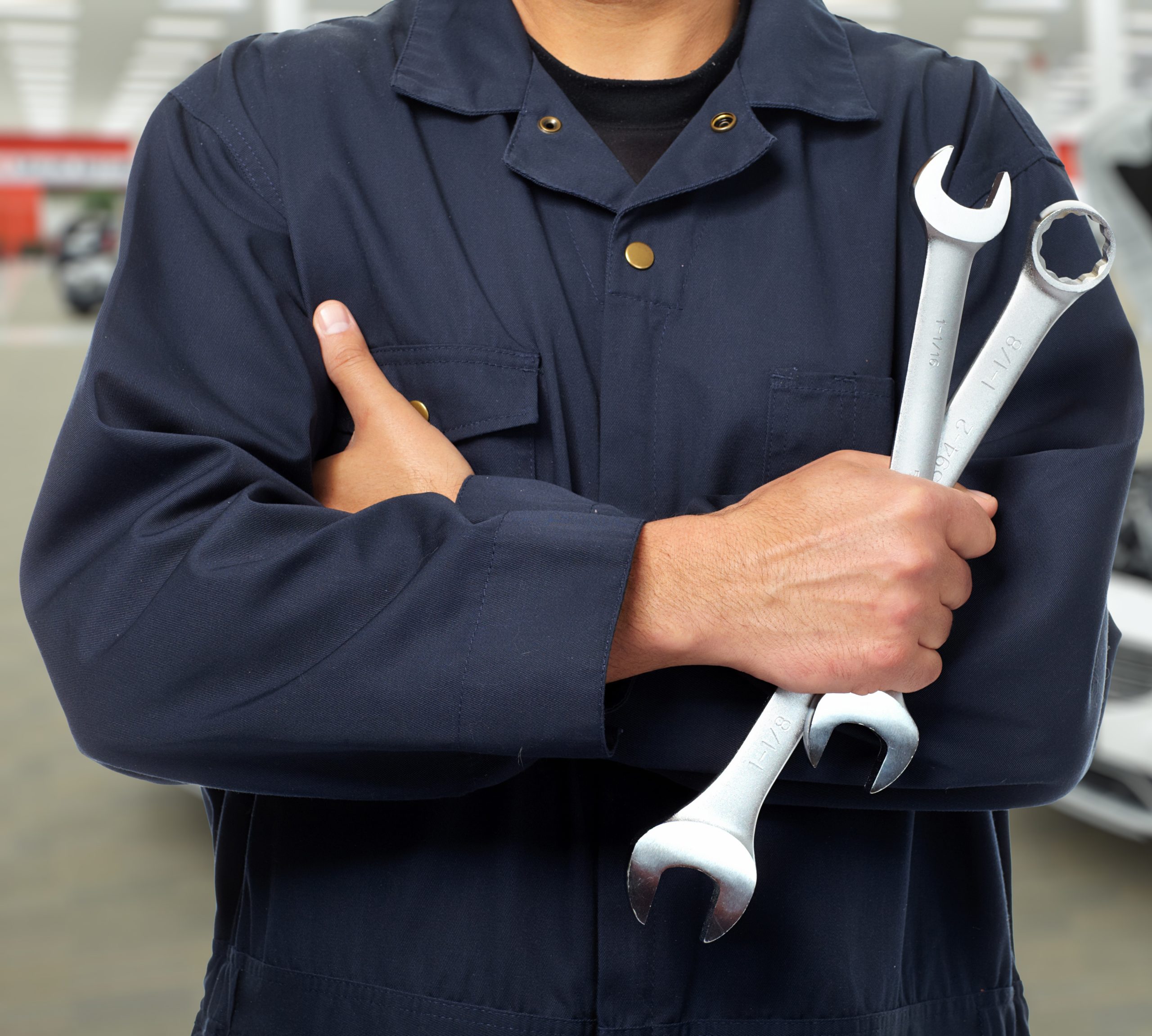 Hands of car mechanic with wrench in auto repair service.